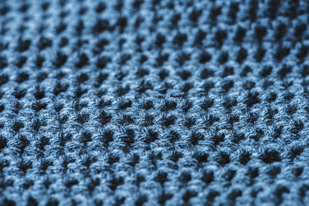 Close-up texture of merino wool fabric showing softness and breathability — essential for merino wool care and long-lasting performance.