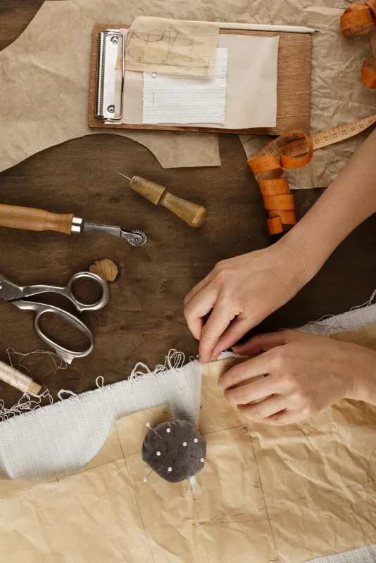 Merino wool care tools and sewing process — scissors, fabric, and patterns showing Mason William Merino’s craftsmanship in maintaining quality wool garments.